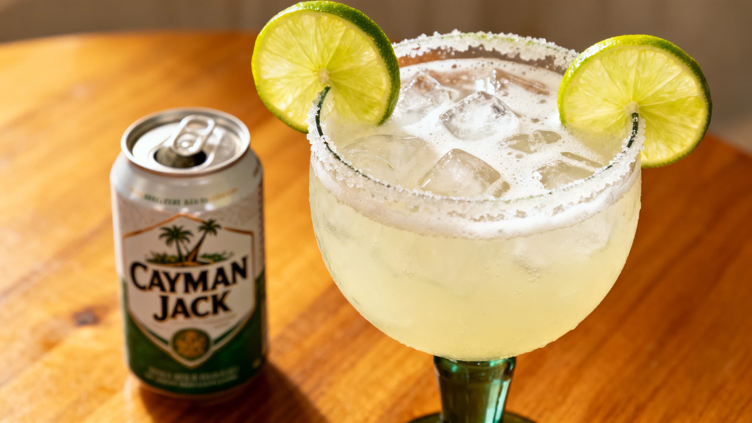 A homemade margarita with fresh lime and a Cayman Jack can side-by-side
